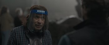 Movie still from “The Bubble” (2022), directed by Judd Apatow – A man wearing a face shield looking out of a window; Close Up shot, Over the shoulder angle