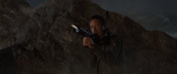 Movie still from “The Bubble” (2022), directed by Judd Apatow – A man is holding a gun in the dark; Close Up shot, Over the shoulder angle