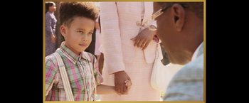 Movie still from “The Burial” (2023), directed by Maggie Betts – A young boy holding hands with an older woman; Close Up shot, Over the shoulder angle