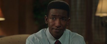 Movie still from “The Burial” (2023), directed by Maggie Betts – A person wearing a shirt and tie; Close Up shot, Over the shoulder angle