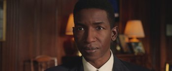 Movie still from “The Burial” (2023), directed by Maggie Betts – A person wearing a suit and tie; Close Up shot, Low angle