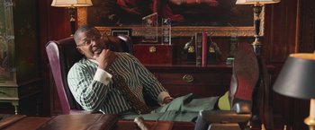 Movie still from “The Burial” (2023), directed by Maggie Betts – A man sitting at a table talking on a phone; Medium shot, Over the shoulder angle