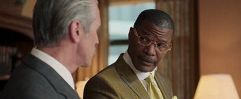 Movie still from “The Burial” (2023), directed by Maggie Betts – A man in a suit and tie talking to another man in a suit and tie; Close Up shot, Over the shoulder angle