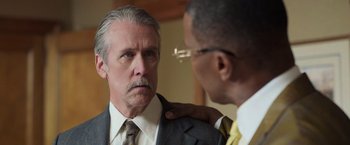 Movie still from “The Burial” (2023), directed by Maggie Betts – A man in a suit and tie looking at a man in a suit; Close Up shot, Over the shoulder angle