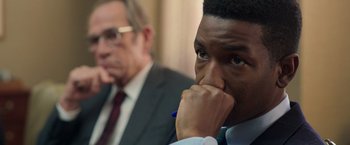 Movie still from “The Burial” (2023), directed by Maggie Betts – A man in a suit and tie sitting next to another man in a suit and tie; Close Up shot, Over the shoulder angle