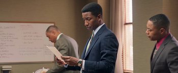 Movie still from “The Burial” (2023), directed by Maggie Betts – A man in a suit and tie looking at a piece of paper; Close Up shot, Over the shoulder angle