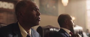 Movie still from “The Burial” (2023), directed by Maggie Betts – A man in a suit and tie looking up at the ceiling; Close Up shot, Low angle