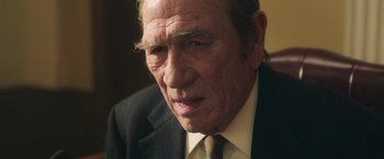 Movie still from “The Burial” (2023), directed by Maggie Betts – An older man wearing a suit and tie; Close Up shot, Over the shoulder angle