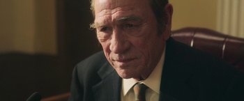 Movie still from “The Burial” (2023), directed by Maggie Betts – An older man wearing a suit and tie; Close Up shot, Over the shoulder angle