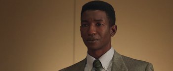 Movie still from “The Burial” (2023), directed by Maggie Betts – A person wearing a suit and tie; Close Up shot, Low angle