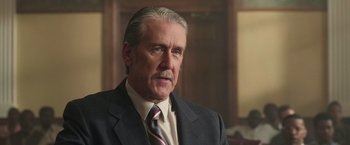 Movie still from “The Burial” (2023), directed by Maggie Betts – An older man wearing a suit and tie; Close Up shot, Over the shoulder angle