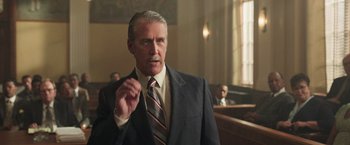 Movie still from “The Burial” (2023), directed by Maggie Betts – An older man wearing a suit and tie in a court room; Close Up shot, Low angle