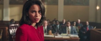 Movie still from “The Burial” (2023), directed by Maggie Betts – A woman in a red dress in front of a group of people; Close Up shot, Over the shoulder angle