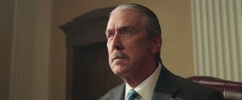 Movie still from “The Burial” (2023), directed by Maggie Betts – An older man in a suit and tie looking off into the distance; Close Up shot, Low angle