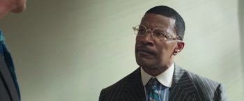 Movie still from “The Burial” (2023), directed by Maggie Betts – An older man in a suit and glasses; Close Up shot, Over the shoulder angle