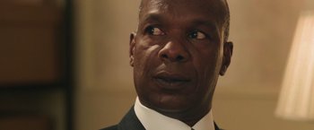 Movie still from “The Burial” (2023), directed by Maggie Betts – A person wearing a suit and tie; Close Up shot, Over the shoulder angle