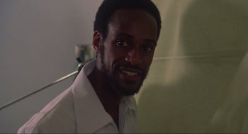 Movie still from “The Burning” (1981), directed by Tony Maylam – A person wearing a white shirt smiling; Close Up shot, Low angle
