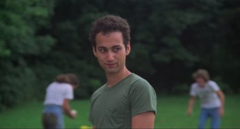 Movie still from “The Burning” (1981), directed by Tony Maylam – A man in a green shirt is standing in the grass; Close Up shot, Low angle