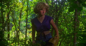 Movie still from “The Burning” (1981), directed by Tony Maylam – A woman holding a catchers mitt while standing in the woods; Medium shot, Low angle