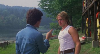 Movie still from “The Burning” (1981), directed by Tony Maylam – A man pointing at another man in a white tank top; Medium shot, Over the shoulder angle