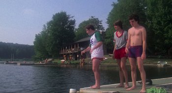 Movie still from “The Burning” (1981), directed by Tony Maylam – A group of young men standing next to a body of water; Wide shot, Low angle