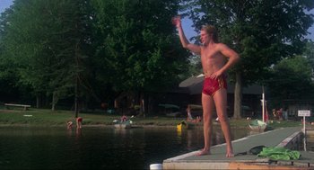 Movie still from “The Burning” (1981), directed by Tony Maylam – A man in red trunks standing on a dock; Wide shot, Low angle