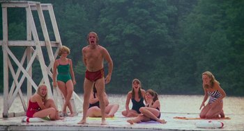 Movie still from “The Burning” (1981), directed by Tony Maylam – A group of people sitting and standing on a dock; Wide shot, Low angle