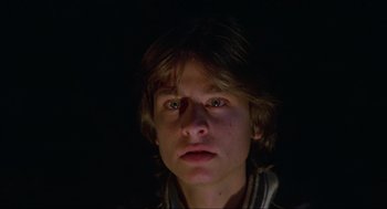 A young man is looking into the camera