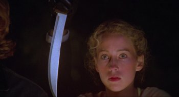 Movie still from “The Burning” (1981), directed by Tony Maylam – A young woman holding a knife in front of her face; Close Up shot, Low angle