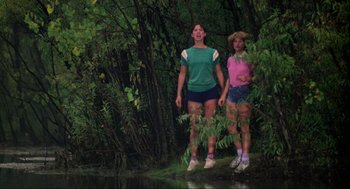 Movie still from “The Burning” (1981), directed by Tony Maylam – Two women standing next to a body of water; Wide shot, Low angle