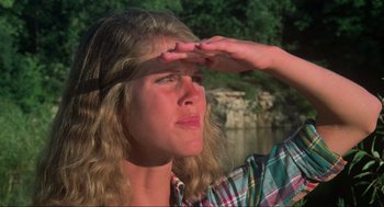 Movie still from “The Burning” (1981), directed by Tony Maylam – A woman with long blonde hair is holding her hand up to her forehead; Close Up shot, Low angle