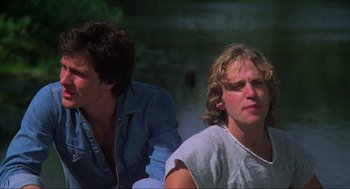 Movie still from “The Burning” (1981), directed by Tony Maylam – Two men sitting next to each other on the beach; Close Up shot, Low angle