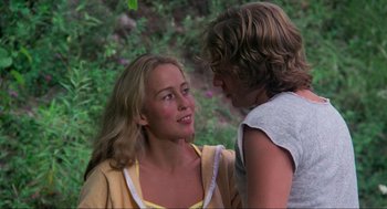 Movie still from “The Burning” (1981), directed by Tony Maylam – A woman sitting next to a man in front of bushes; Medium shot, Over the shoulder angle