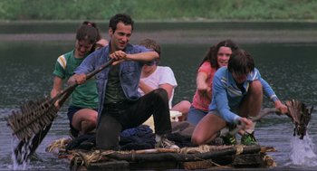 Movie still from “The Burning” (1981), directed by Tony Maylam – A group of young people on a raft in the water; Medium shot, High angle
