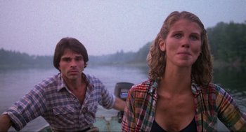 Movie still from “The Burning” (1981), directed by Tony Maylam – A man and a woman standing next to each other on a boat; Medium shot, Low angle