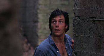 Movie still from “The Burning” (1981), directed by Tony Maylam – A man with wet hair is standing next to a tree; Close Up shot, Low angle