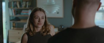 Movie still from “The Burning Sea” (2021), directed by John Andreas Andersen – A woman sitting in front of a man in front of a mirror; Close Up shot, Over the shoulder angle