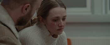 Movie still from “The Burning Sea” (2021), directed by John Andreas Andersen – A young woman with a tear in her eye; Close Up shot, Over the shoulder angle