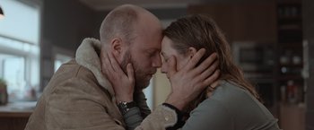 Movie still from “The Burning Sea” (2021), directed by John Andreas Andersen – A man and a woman are kissing in a room; Close Up shot, Low angle