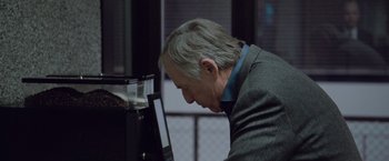 Movie still from “The Burning Sea” (2021), directed by John Andreas Andersen – An older man looking at a computer screen; Close Up shot, High angle