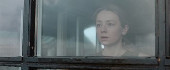 Movie still from “The Burning Sea” (2021), directed by John Andreas Andersen – A woman looking out of a window in a train; Close Up shot, Over the shoulder angle