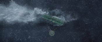 Movie still from “The Burning Sea” (2021), directed by John Andreas Andersen – An aerial view of a boat in the water; Extreme Wide shot, Overhead angle