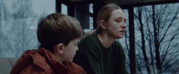 Movie still from “The Burning Sea” (2021), directed by John Andreas Andersen – A woman sitting next to a young boy in front of a window; Close Up shot, Over the shoulder angle