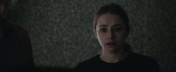 Movie still from “The Burning Sea” (2021), directed by John Andreas Andersen – A young woman with a sad look on her face; Close Up shot, Over the shoulder angle