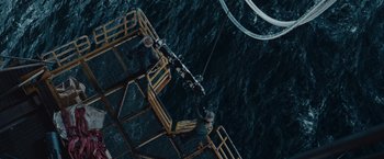 Movie still from “The Burning Sea” (2021), directed by John Andreas Andersen – Three people are on a platform in the water; Extreme Wide shot, Overhead angle