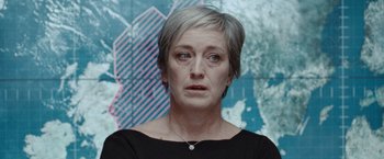 Movie still from “The Burning Sea” (2021), directed by John Andreas Andersen – An older woman with short grey hair wearing a black shirt; Close Up shot, Low angle