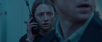 Movie still from “The Burning Sea” (2021), directed by John Andreas Andersen – A woman on a cell phone in front of a mirror; Close Up shot, Low angle