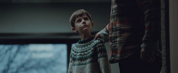 Movie still from “The Burning Sea” (2021), directed by John Andreas Andersen – A young boy standing next to an older person; Medium shot, Over the shoulder angle