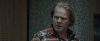 Movie still from “The Burning Sea” (2021), directed by John Andreas Andersen – A person wearing a plaid shirt; Close Up shot, Over the shoulder angle