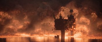 Movie still from “The Burning Sea” (2021), directed by John Andreas Andersen – An oil rig on fire in the middle of the night; Extreme Wide shot, Low angle